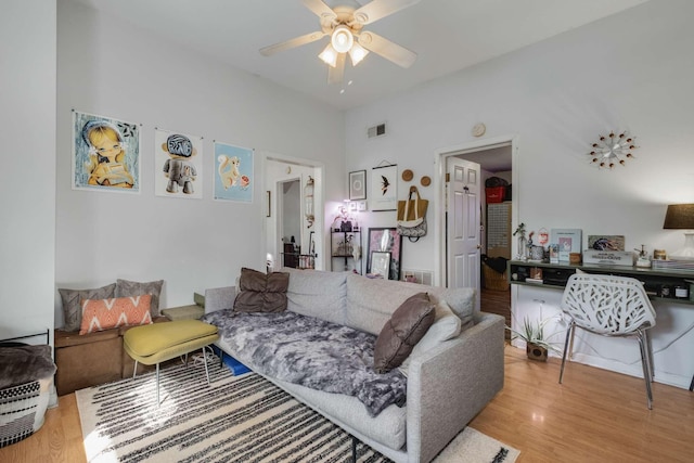 living area featuring wood finished floors, visible vents, and ceiling fan