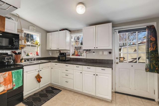 kitchen with a sink, dark countertops, black appliances, and white cabinets