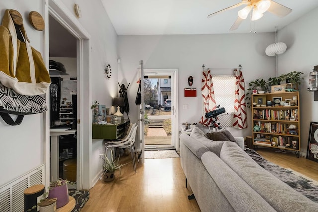 living room featuring wood finished floors, visible vents, and ceiling fan