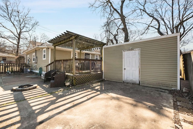 back of house featuring fence, a fire pit, a pergola, and a patio area