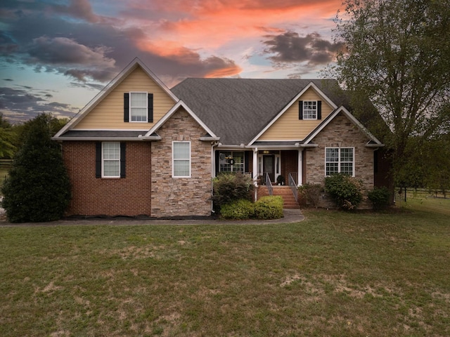 craftsman house with a yard and stone siding