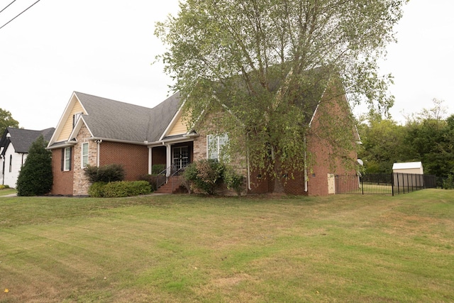 view of front of property featuring brick siding, a front lawn, and fence