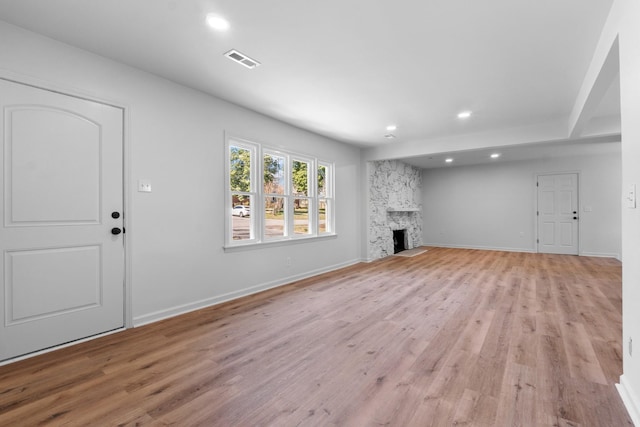 unfurnished living room with light wood-style floors, recessed lighting, a fireplace, and visible vents