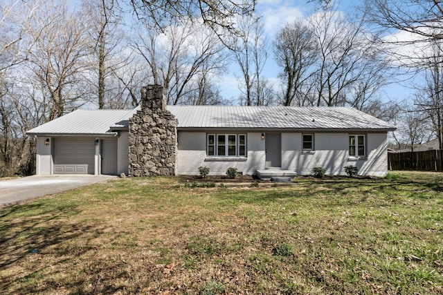 ranch-style home with a front lawn, fence, concrete driveway, metal roof, and a garage