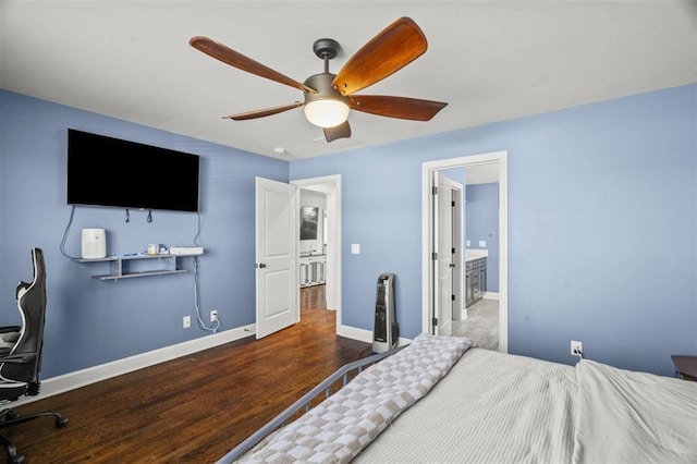 bedroom with connected bathroom, wood finished floors, baseboards, and ceiling fan