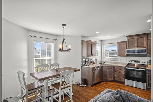 kitchen with baseboards, recessed lighting, dark wood-style flooring, a sink, and appliances with stainless steel finishes