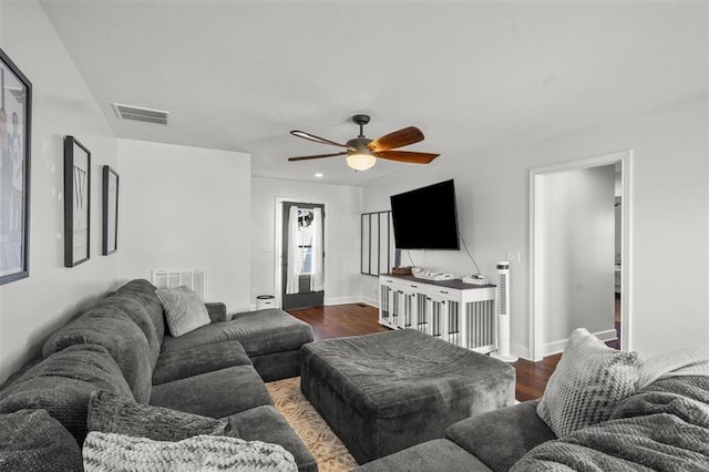 living room featuring a ceiling fan, dark wood-type flooring, baseboards, and visible vents