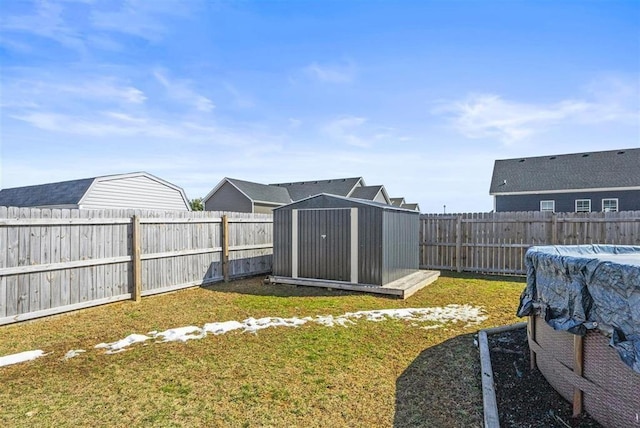 view of yard featuring an outdoor structure, a storage unit, a fenced backyard, and a fenced in pool