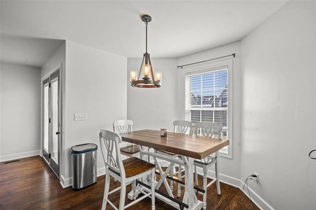 dining space featuring an inviting chandelier, visible vents, wood finished floors, and baseboards