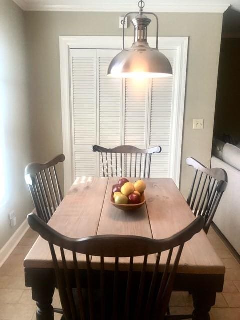 dining area with baseboards, light tile patterned flooring, and crown molding