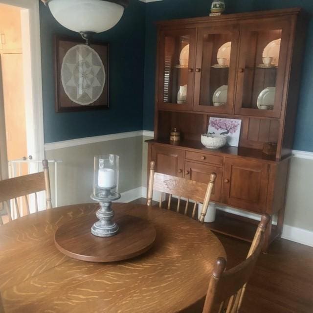 dining space featuring baseboards and dark wood-style floors