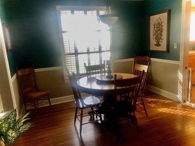 dining room featuring wood finished floors, baseboards, and wainscoting