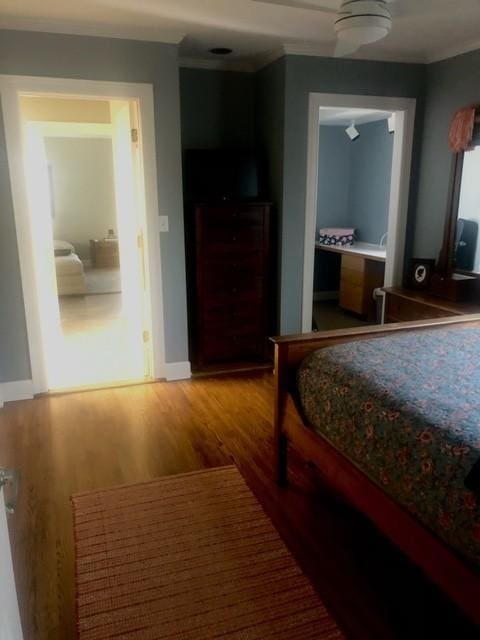 bedroom featuring crown molding, wood finished floors, and baseboards