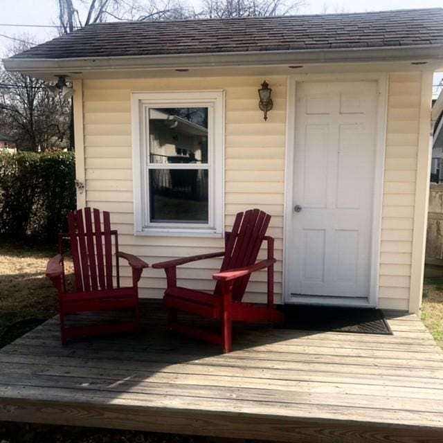 exterior space featuring a wooden deck and roof with shingles