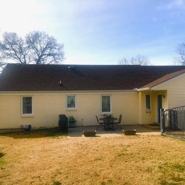 rear view of property with a patio area and roof with shingles