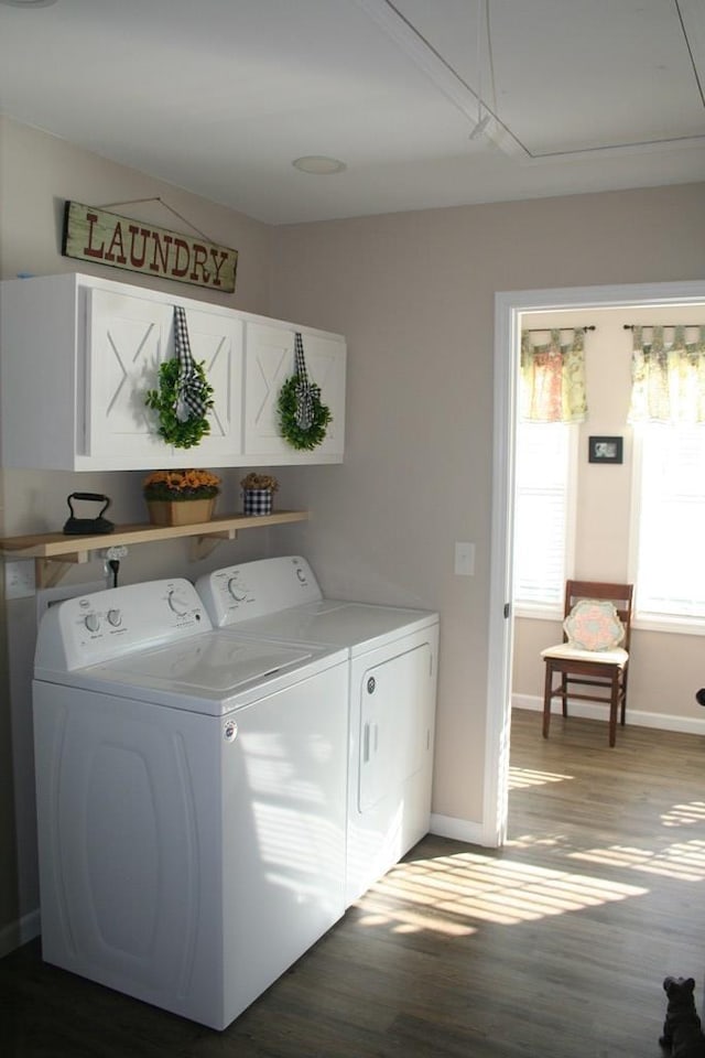 washroom featuring laundry area, washing machine and dryer, attic access, and wood finished floors