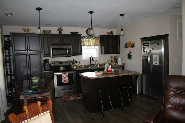 kitchen featuring a sink, a center island, dark wood-style floors, and stainless steel appliances