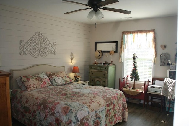 bedroom featuring ceiling fan, visible vents, and wood finished floors