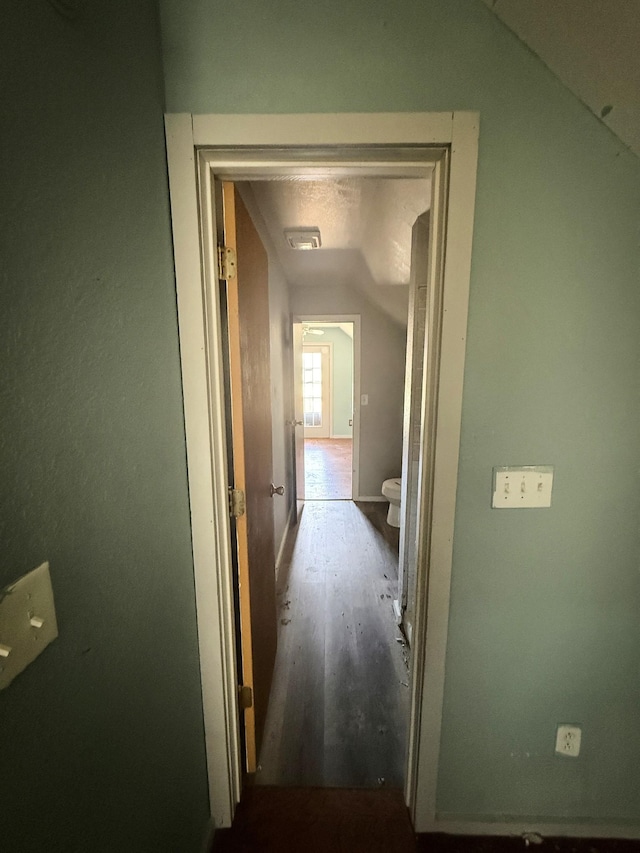 corridor featuring wood finished floors and vaulted ceiling