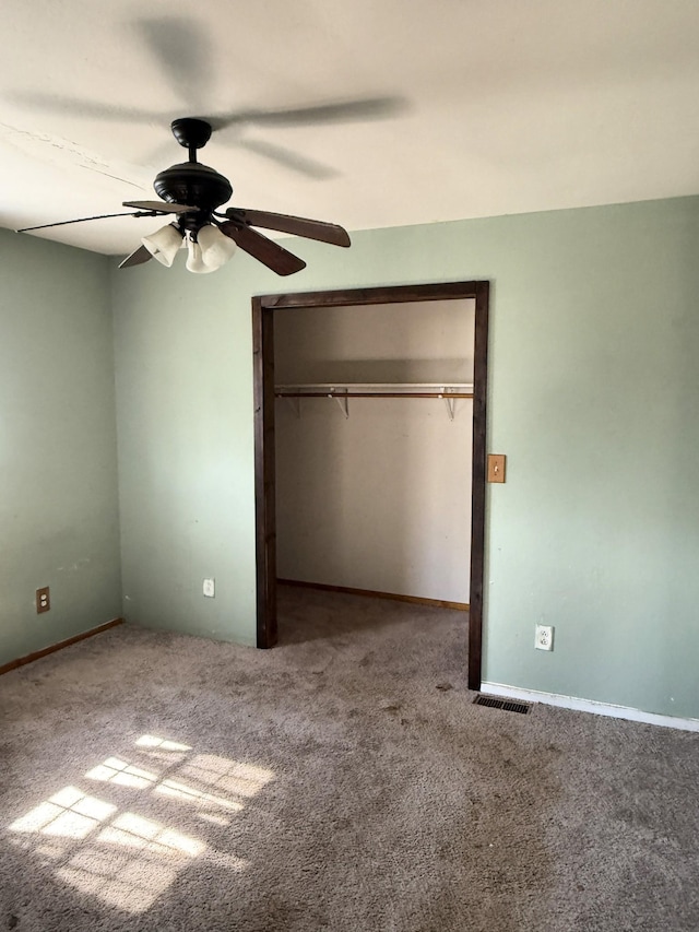 unfurnished bedroom featuring visible vents, a ceiling fan, a closet, and carpet flooring