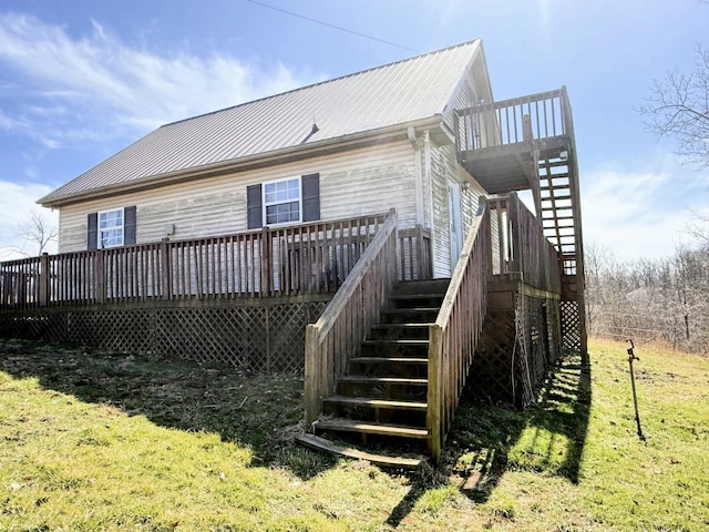 back of house featuring a deck, stairway, a yard, and metal roof