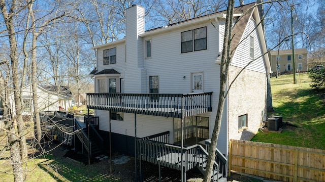 rear view of property featuring stairway, cooling unit, a wooden deck, a chimney, and brick siding