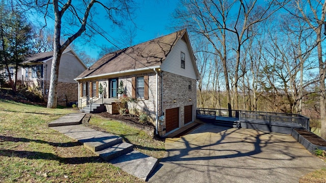 view of front facade with brick siding, a front lawn, aphalt driveway, and a garage