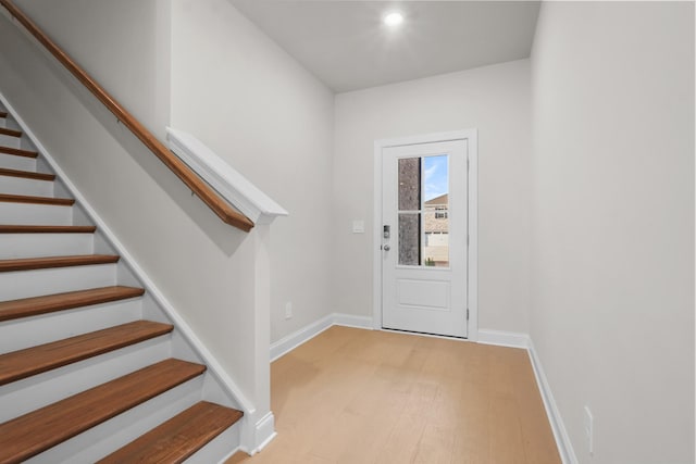 entrance foyer featuring light wood finished floors, stairs, and baseboards