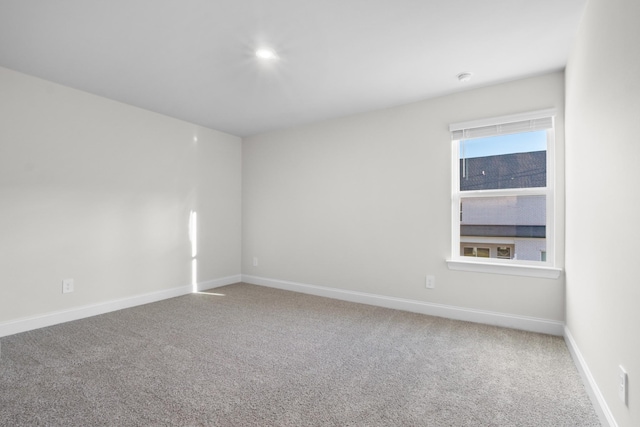 spare room featuring baseboards and carpet flooring