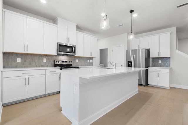 kitchen featuring visible vents, a center island with sink, appliances with stainless steel finishes, and a sink