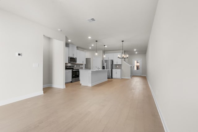 unfurnished living room featuring visible vents, recessed lighting, a sink, light wood-style floors, and a chandelier