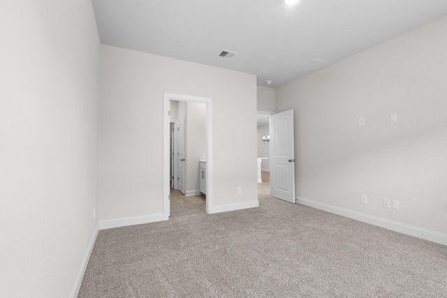 unfurnished bedroom with visible vents, light carpet, and baseboards