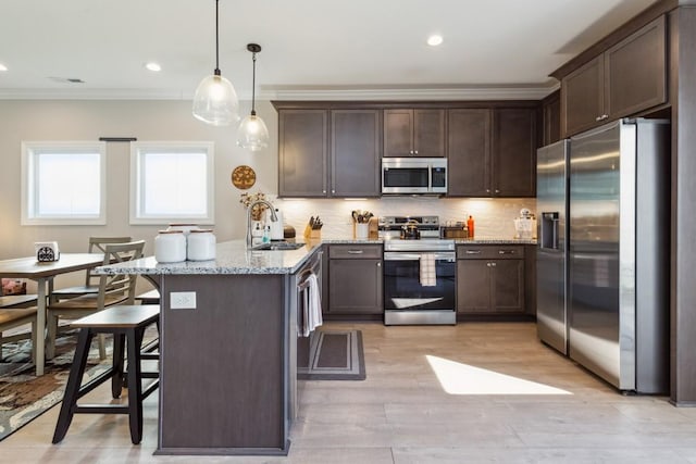 kitchen featuring ornamental molding, a sink, stainless steel appliances, a peninsula, and dark brown cabinets