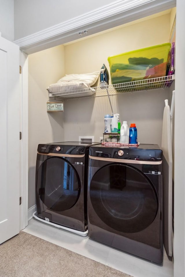 washroom featuring washer and dryer, carpet, and laundry area