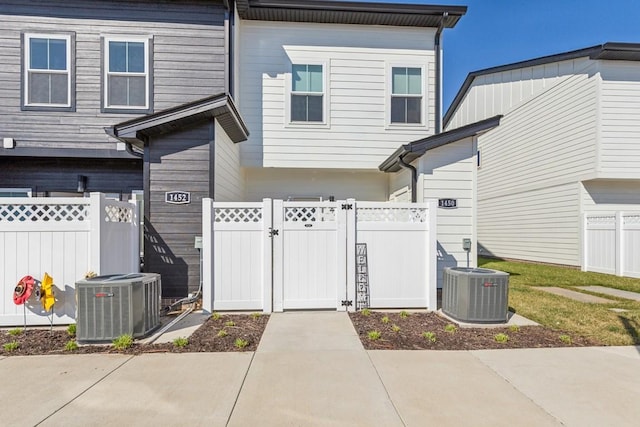 exterior space featuring fence, central AC, and a gate