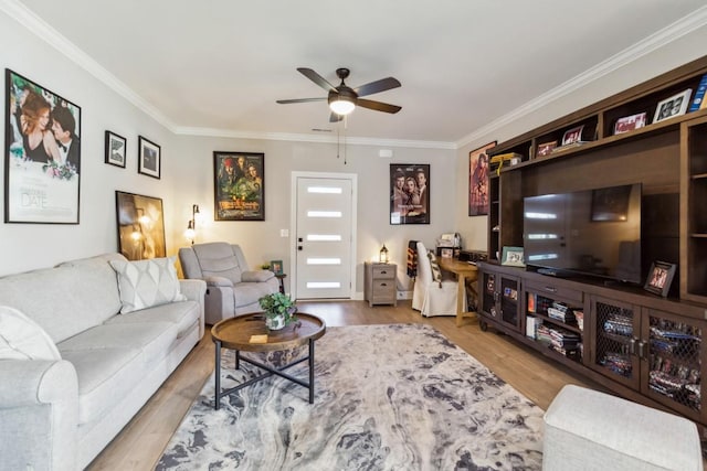 living room featuring ceiling fan, visible vents, wood finished floors, and crown molding