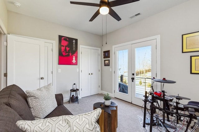 living area featuring visible vents, light carpet, a ceiling fan, french doors, and baseboards