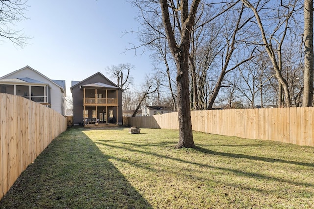 view of yard featuring a fenced backyard and a sunroom