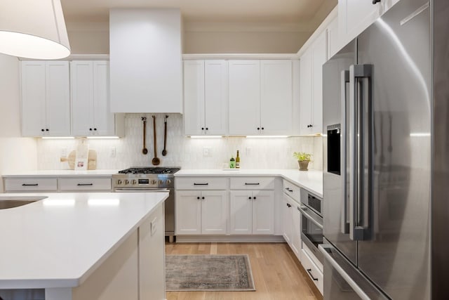 kitchen with decorative backsplash, white cabinetry, and appliances with stainless steel finishes