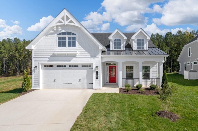 view of front facade with driveway, a front lawn, a standing seam roof, a porch, and an attached garage