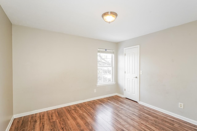 unfurnished room with baseboards and wood finished floors