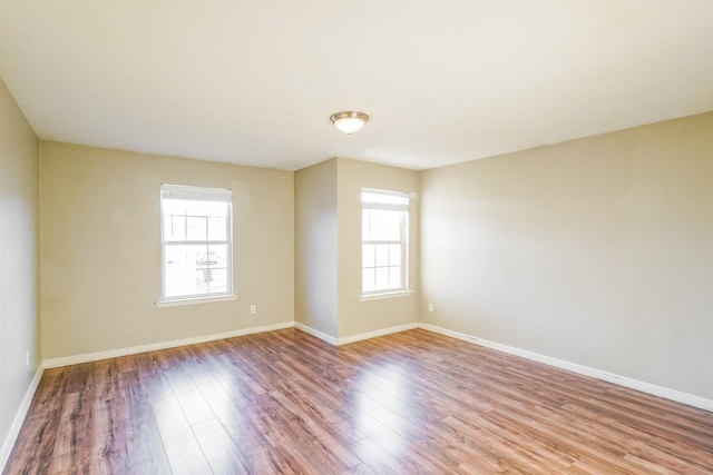 unfurnished room featuring baseboards and wood finished floors