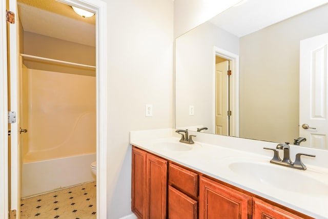 full bath featuring double vanity, toilet, tile patterned floors, and a sink