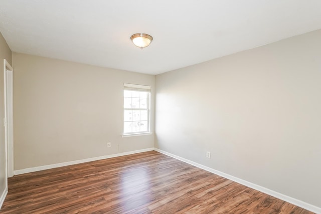 empty room featuring wood finished floors and baseboards