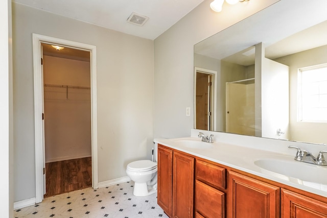 full bath featuring toilet, an enclosed shower, visible vents, and a sink