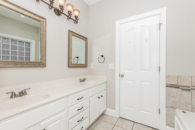 bathroom featuring tile patterned floors, double vanity, a tub, and a sink