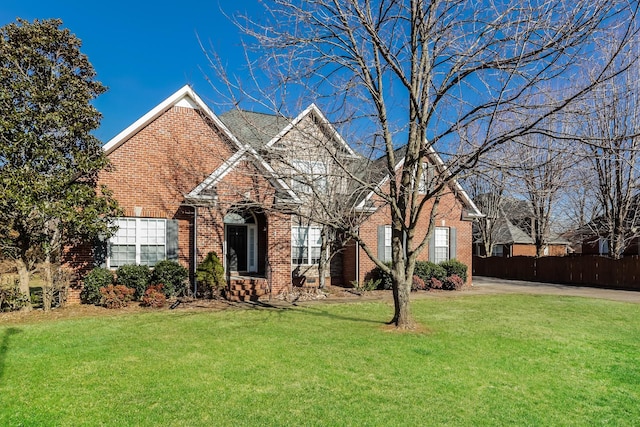 traditional-style house featuring brick siding and a front lawn