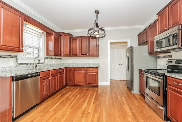 kitchen with light stone counters, stainless steel appliances, light wood-style floors, and ornamental molding