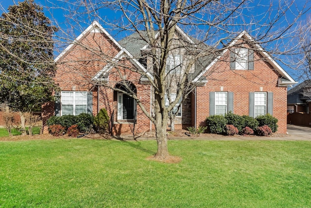 traditional-style home with a front yard and brick siding