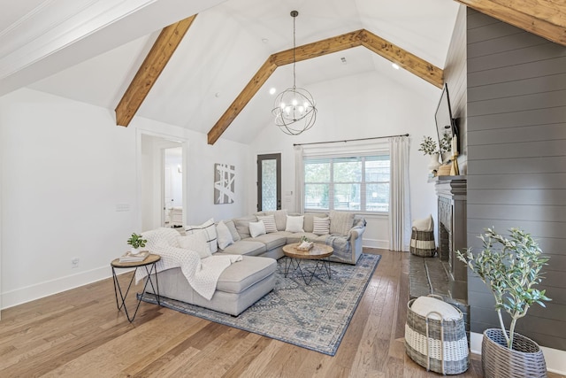 living area featuring hardwood / wood-style floors, an inviting chandelier, beamed ceiling, and high vaulted ceiling